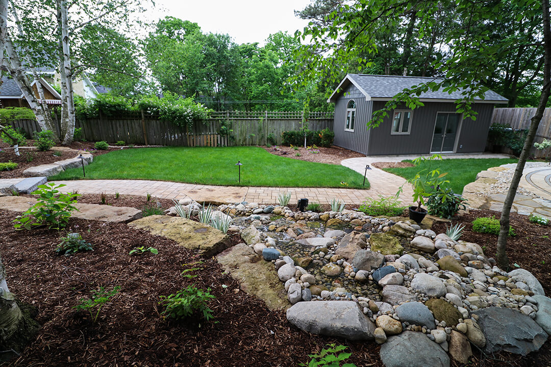 Pondless stream using natural river rock by A Touch of Dutch Landscaping