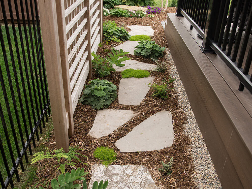 Low maintenance perennials with mulch and stone walkway